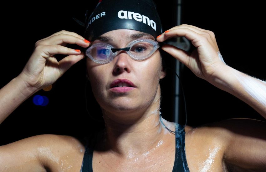 Vrouw met badmuts en duikbril die recht in de camera kijkt