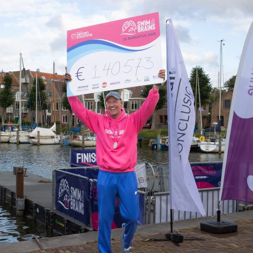 Man met grote cheque in handen met geldbedrag van 140.000 euro.