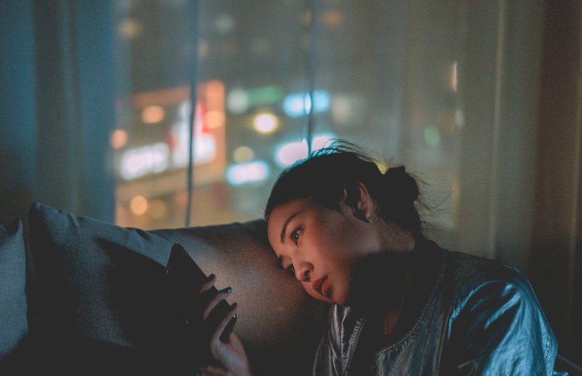 Meisje kijkt verdrietig naar haar telefoon