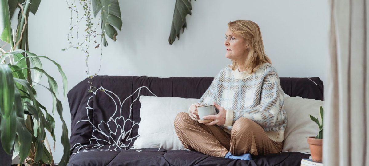 vrouw op bank met bezorgde gezichtsuitdrukking