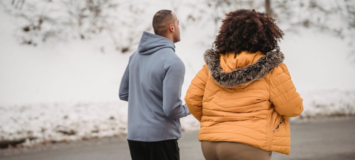 vrouw met overgewicht loopt hard naast een man